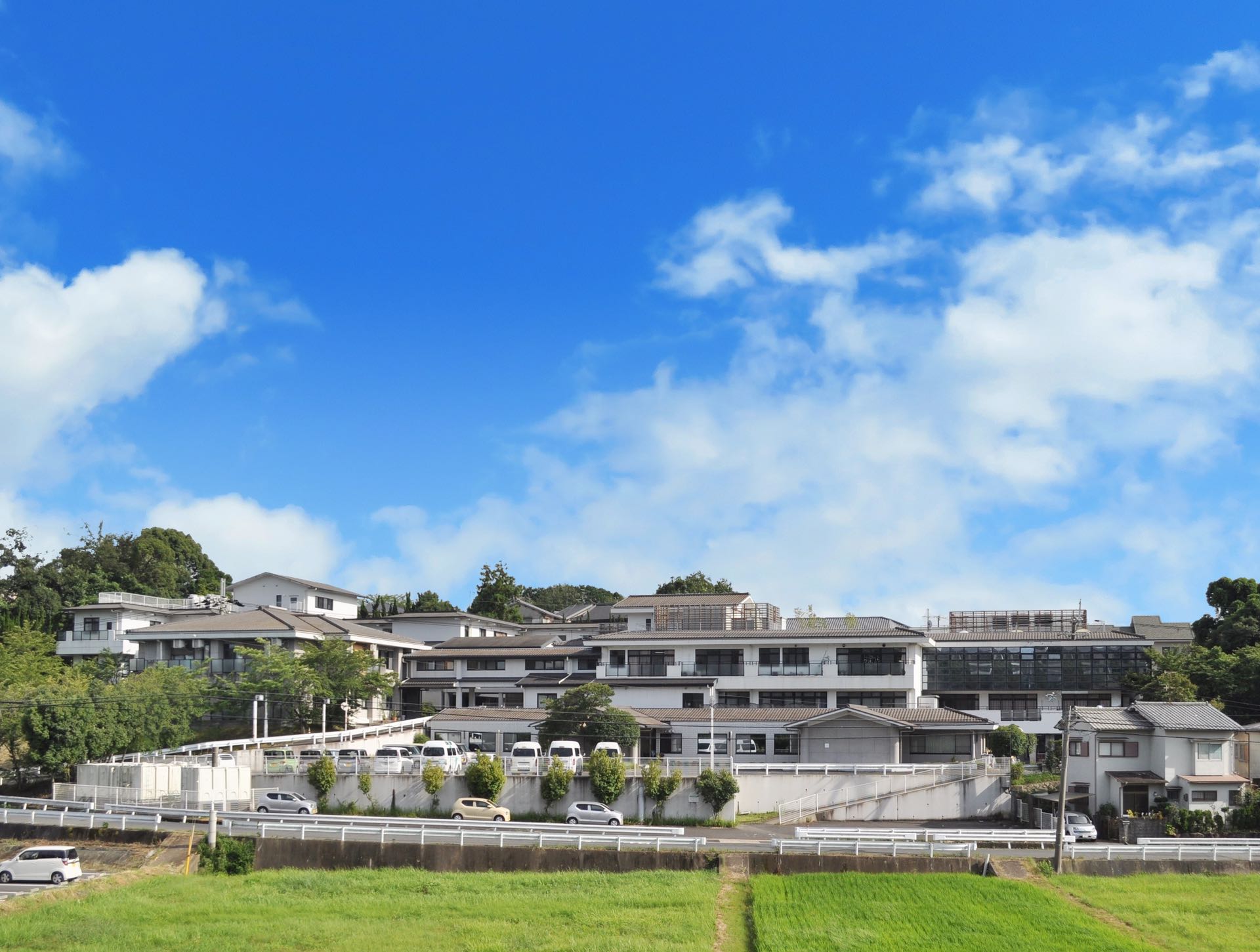 介護施設の建物外観。複数棟の施設が駐車場とともに見える。